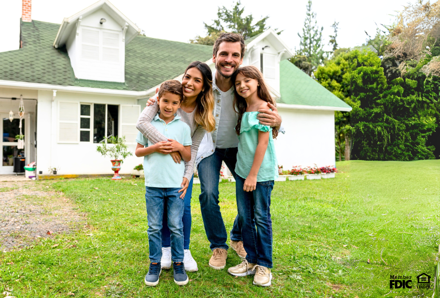 a family poses in front of the home they just bought instead of renting