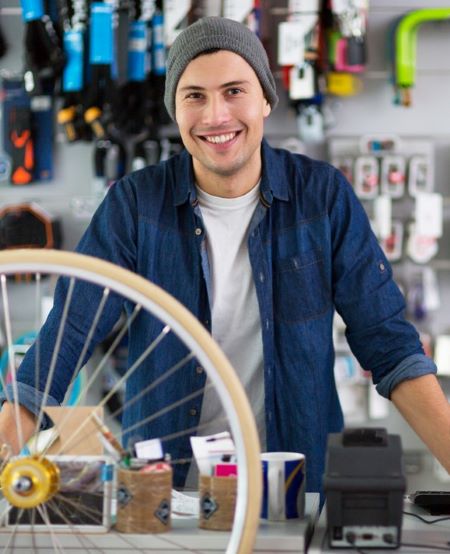 a man happily smiles in his bicycle store