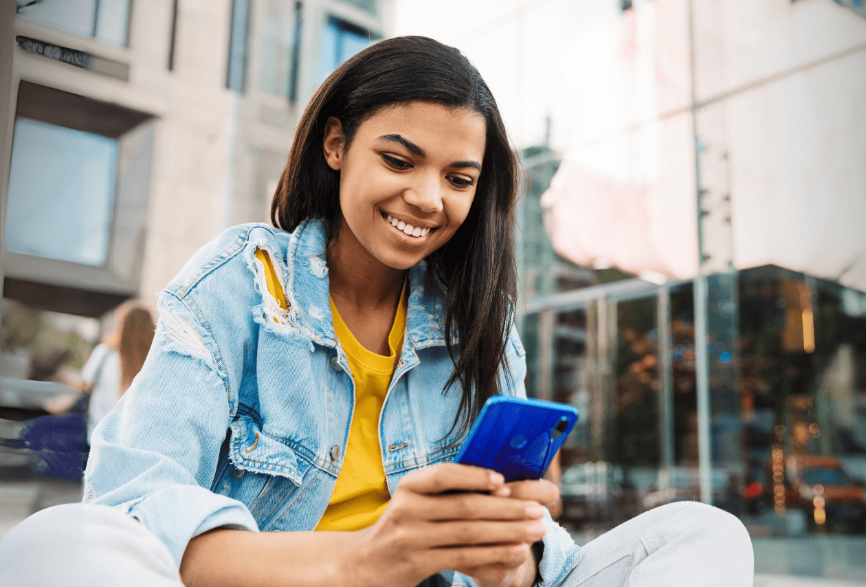 College student on her mobile device managing the best student bank accounts.