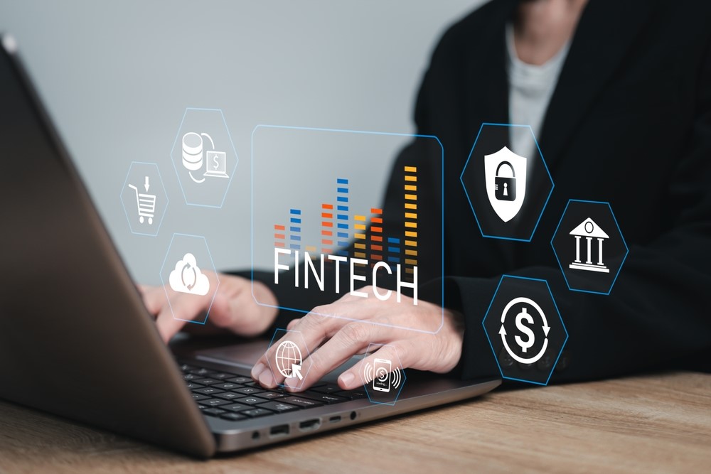 photo of woman typing on laptop with visual of Fintech charts and icons