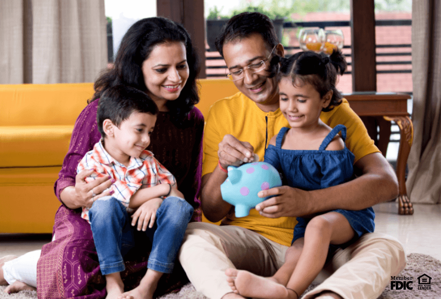 Parents teaching their kids how to save money using a piggy bank