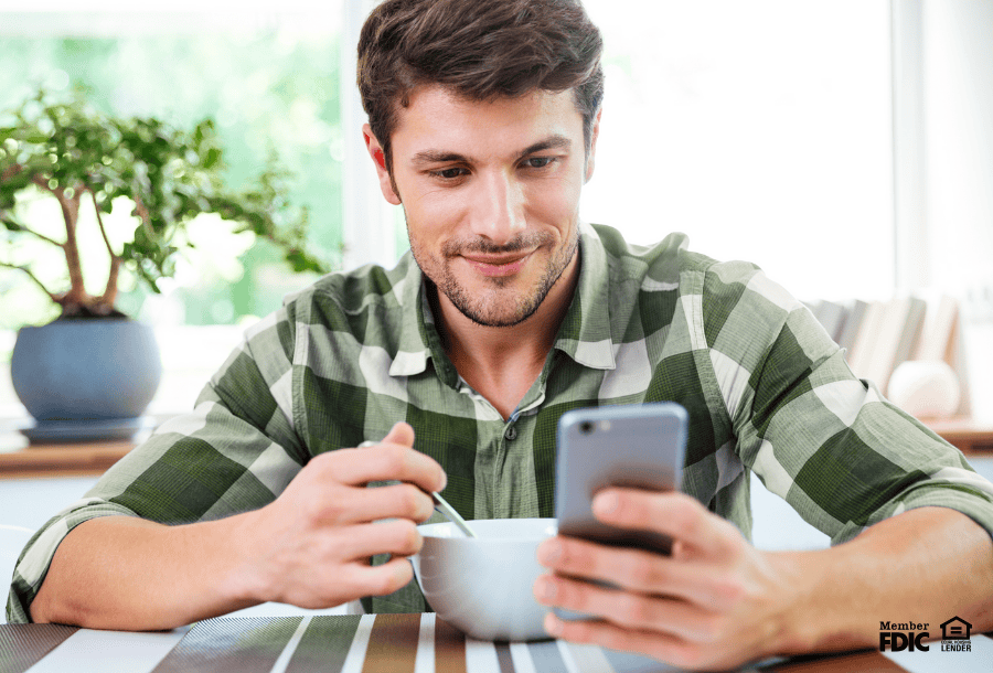 Man looking at his mobile phone while checking his credit score.