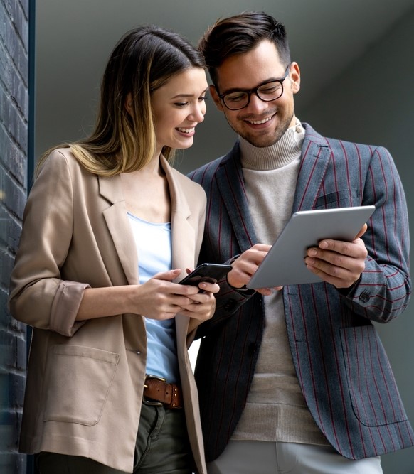 two coworkers go over a work project on an tablet together