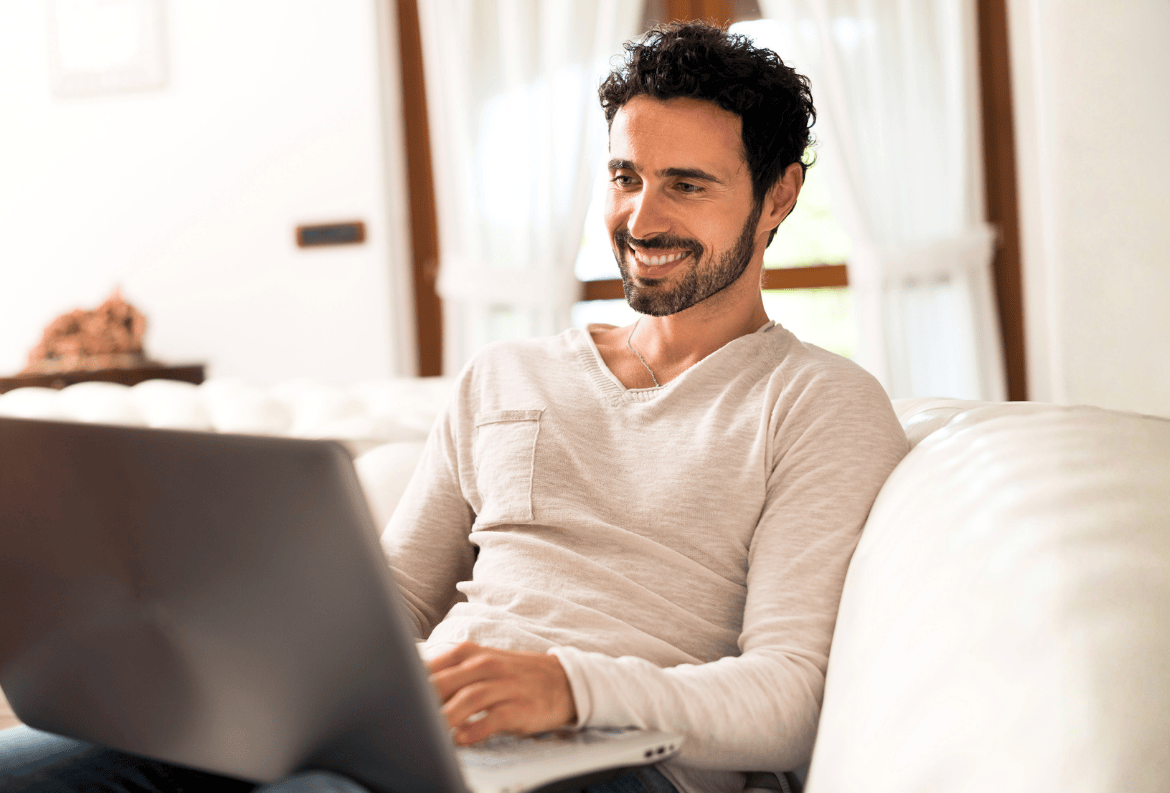 Man using s laptop to compare the pros and cons of CD term loans.
