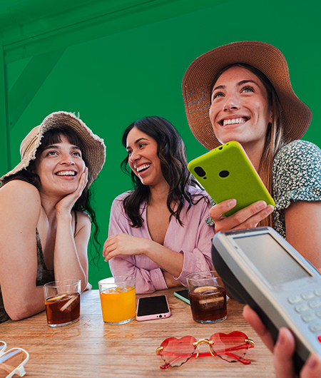 three friends having lunch and one paying with her digital wallet