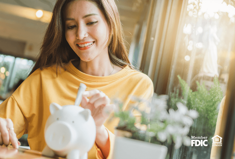 a woman uses a piggy bank to symbolize the importance of CDS and money market accounts