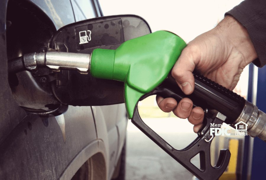 an individual puts gas in their car's tank while using their Academy Bank Rewards checking account gas savings rewards.