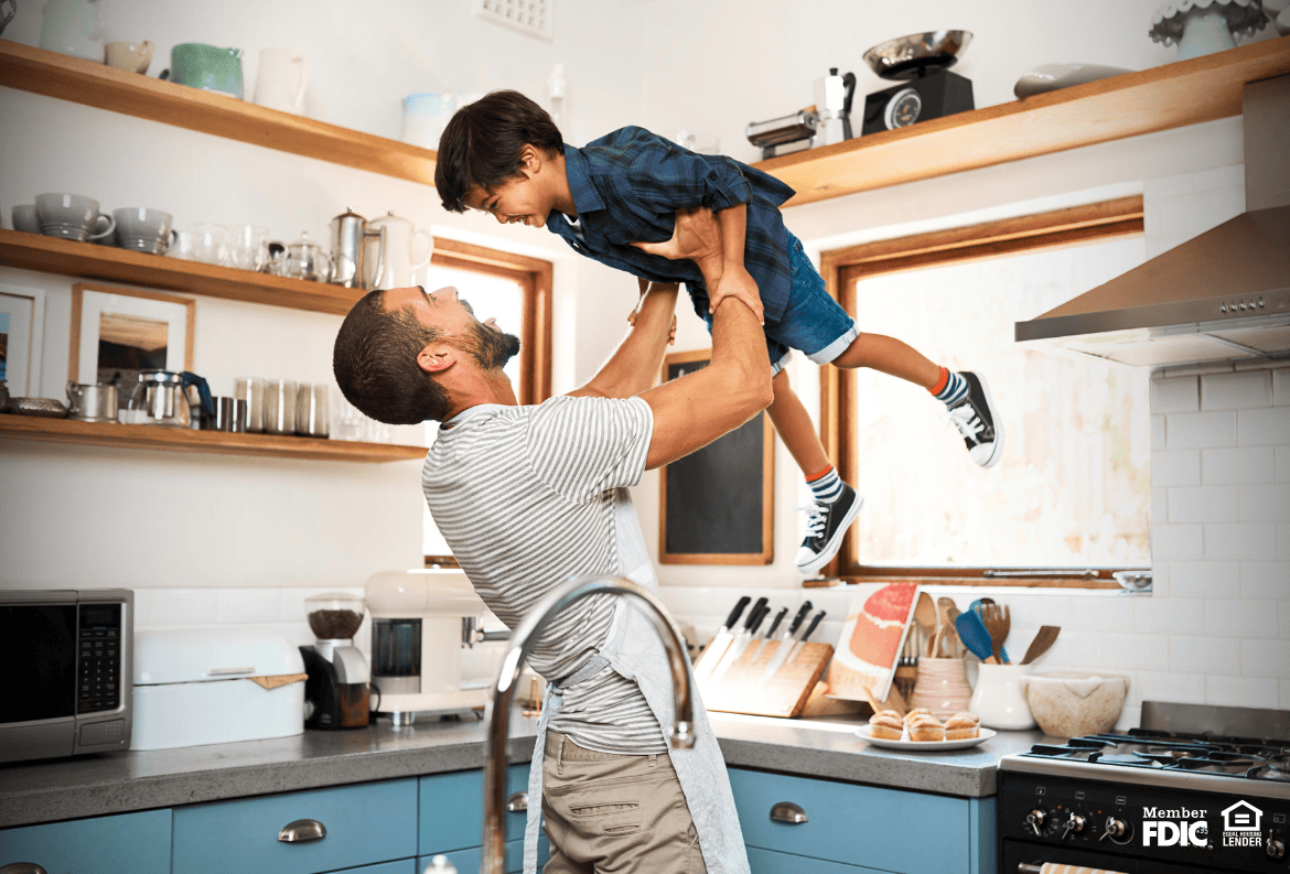 Homeowner playing with his son in their home, where they have both a HELOC and a mortgage.