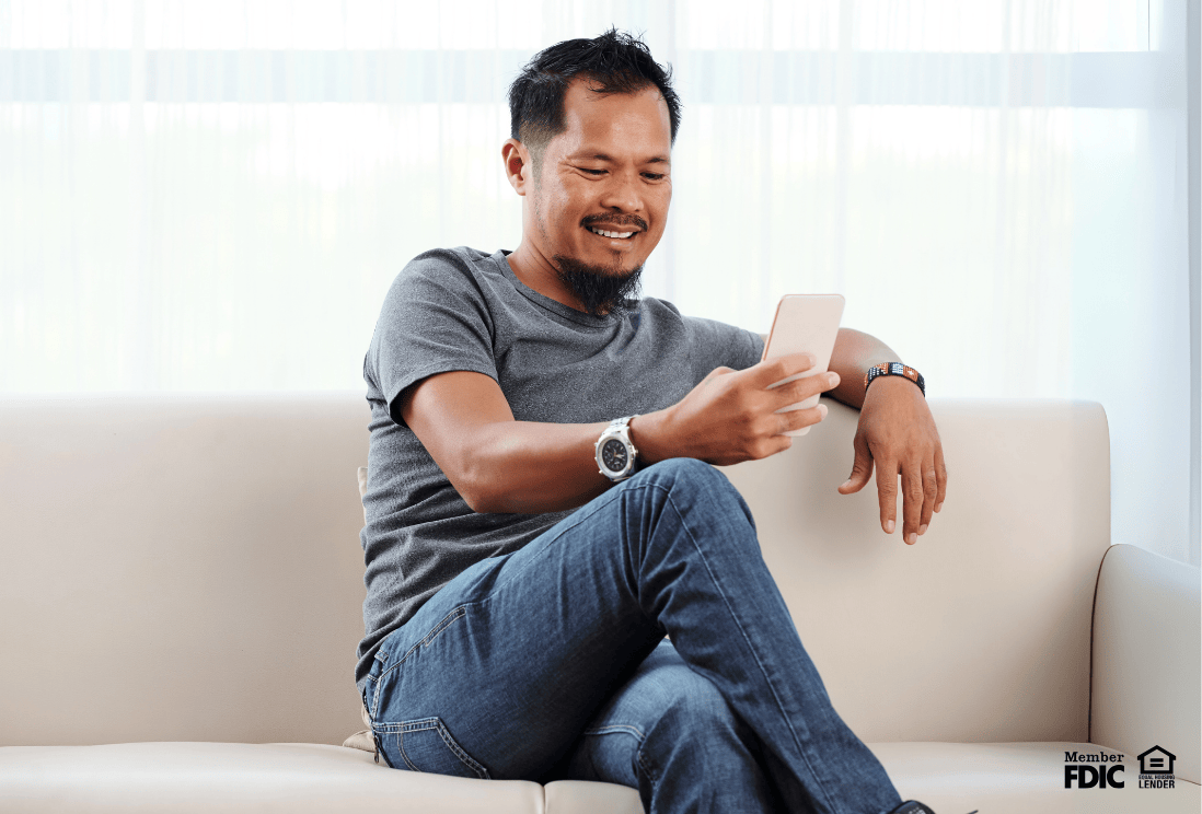 Man using his smartphone to review the loan terms on his mortgage.