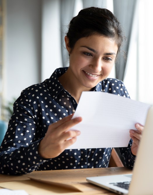 a young woman reads her bank statement