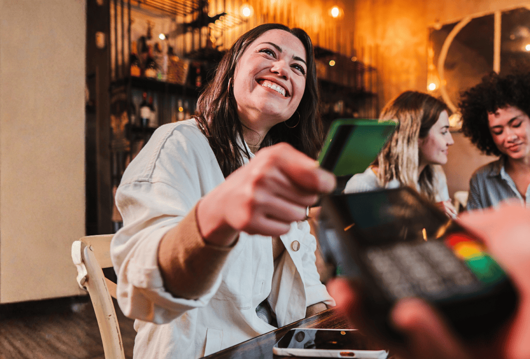 Woman using her debit card to pay for dinner.