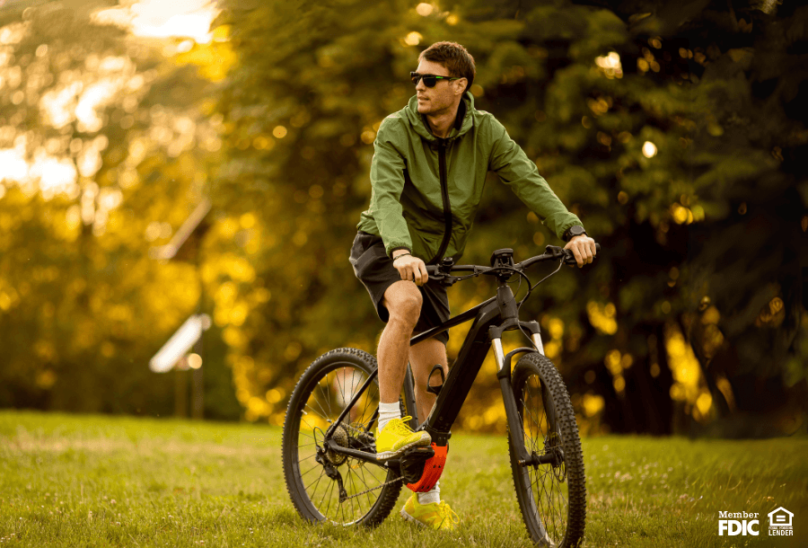 a man rides  his bike through the lawn at a park