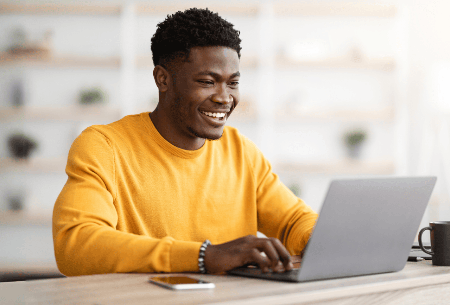 Young adult using his laptop to refinance his student loans.