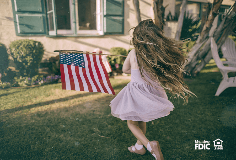 a little girl in a pink dress twirls with an American flag