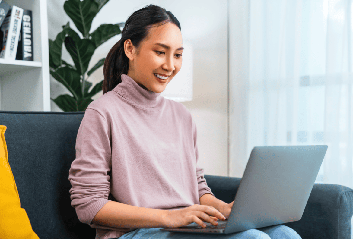 Woman using laptop to learn about Equifax, Experian, and TransUnion credit bureaus.