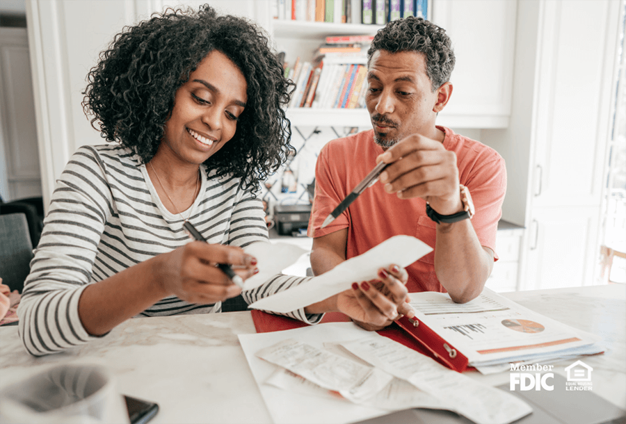 a man and woman review bills while deciding how to use their tax refund