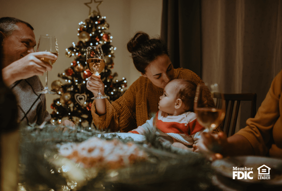 a family shares a holiday meal together with a holiday tree in the back