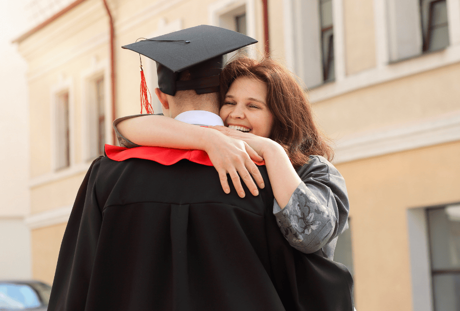 Mother hugging her son who just graduated from college. Here's how to financially prepare your college grads.