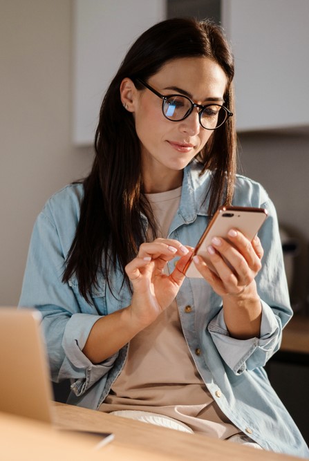 a woman goes over her online banking on her cell phone app