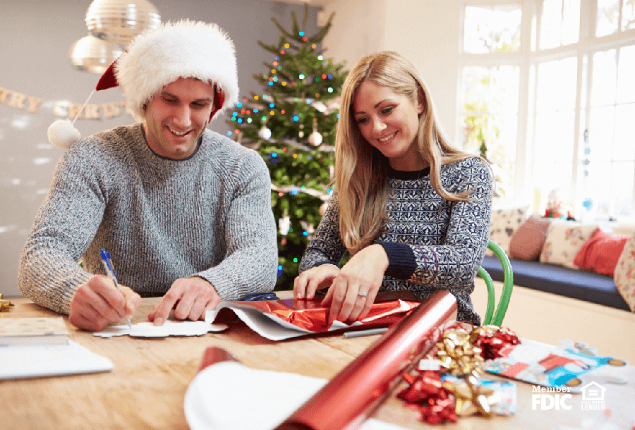 a man and woman wrap holiday gifts after doing their shopping early
