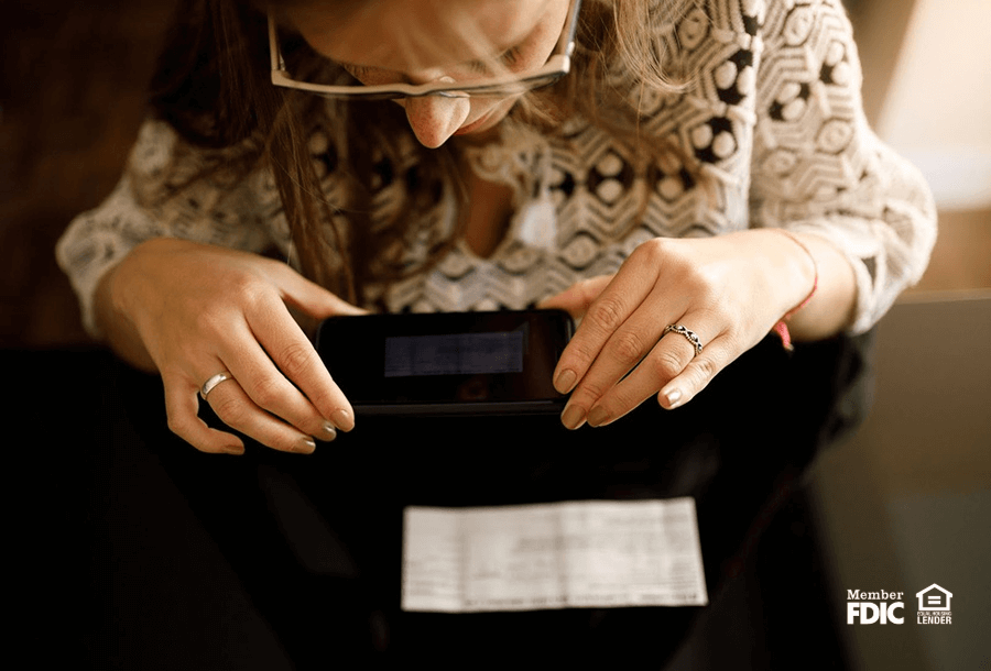 a woman mobile deposits a check through her online banking