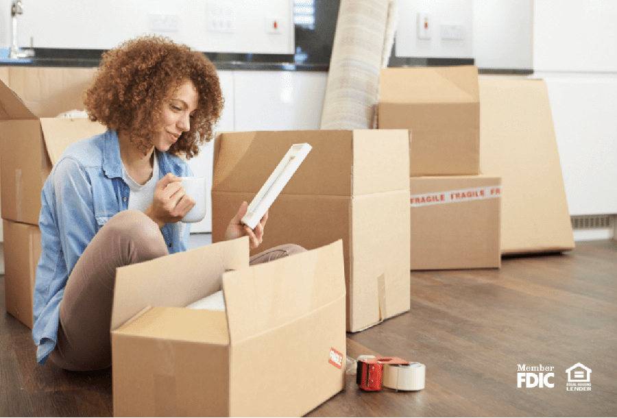 a happy woman unpacks in her new house she bought with a great mortgage