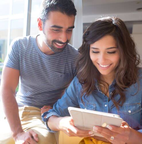 a man and woman research different types of checking accounts for a best fit