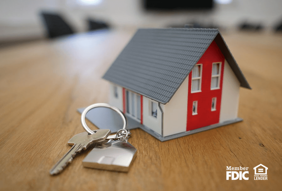 a small house toy sitting next to a real house key