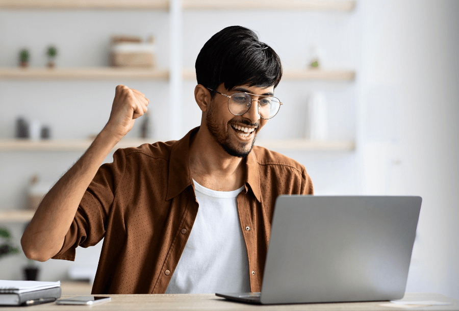 Man on his laptop who is happy about raising his Vantage credit score.