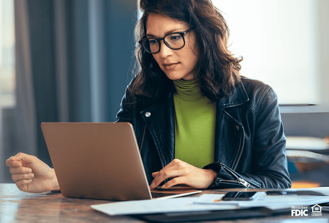 Woman using her laptop, determining if she is reading a spoofing email.