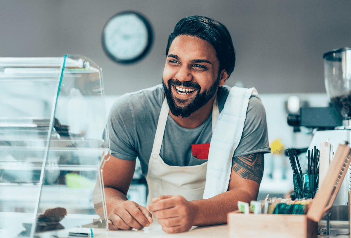 Happy business owner opening shop with money from a small business SBA loan