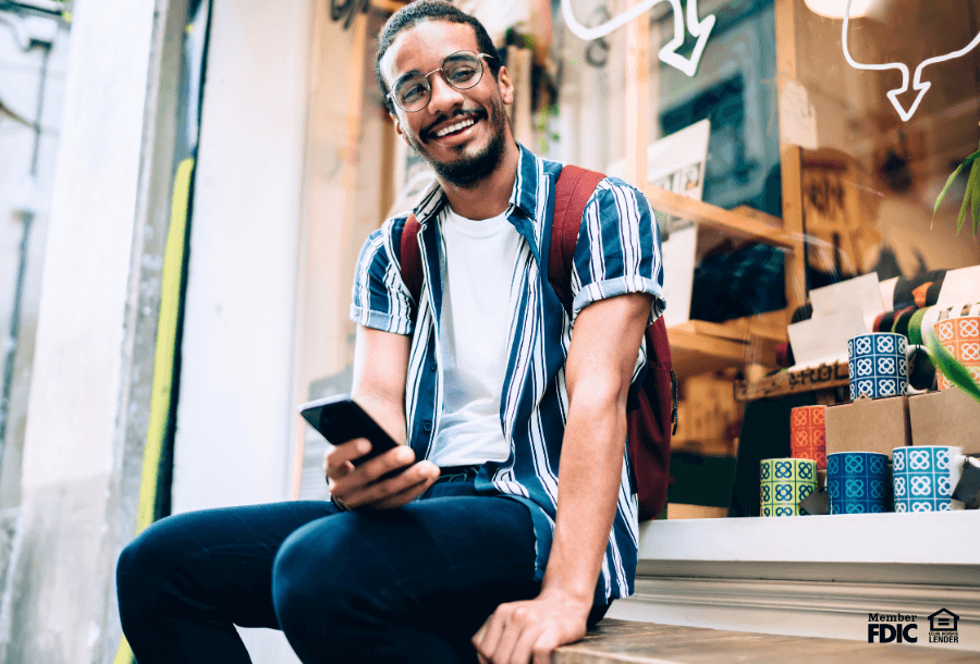 Young man learning surprising facts about credit on his mobile device.