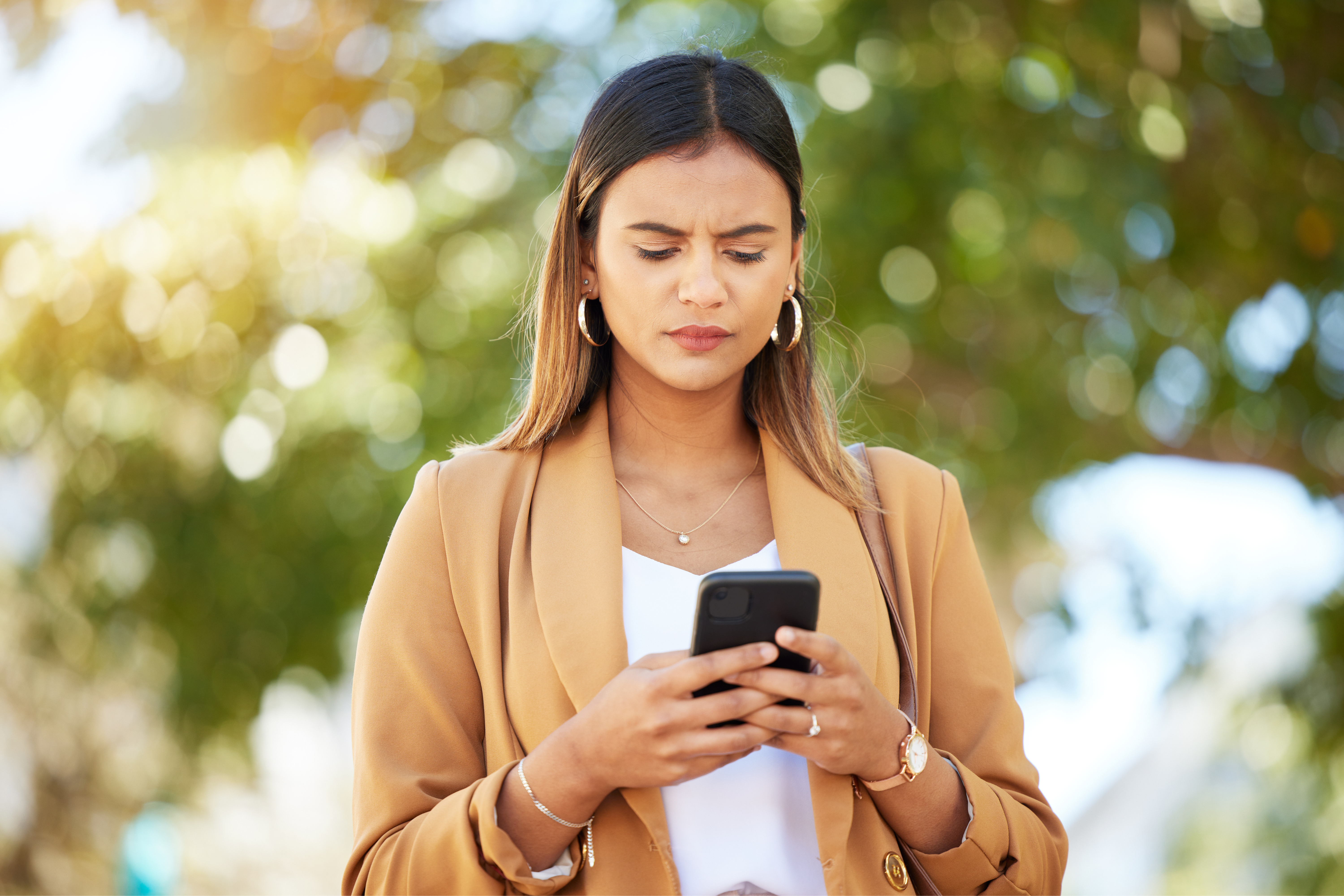 a woman checks her phone to delete a scam text message