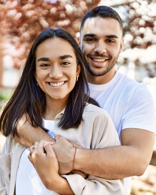 a young couple snuggle outside