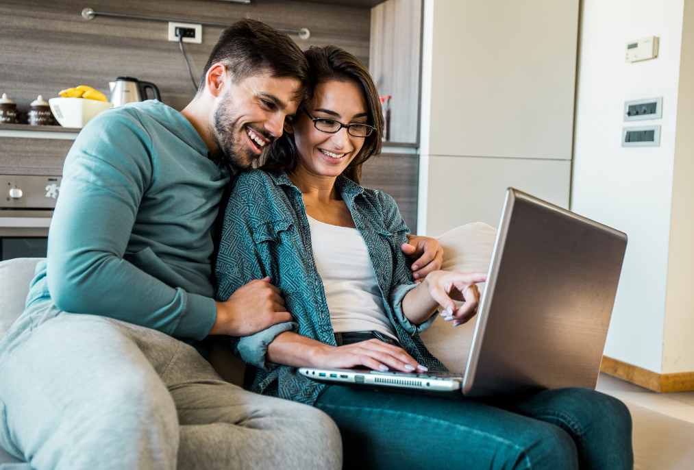 A young couple looking at their laptop