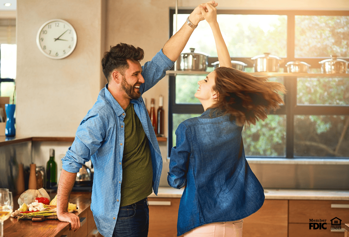 couple dancing in the kitchen, which they renovated with a cash-out refinance.