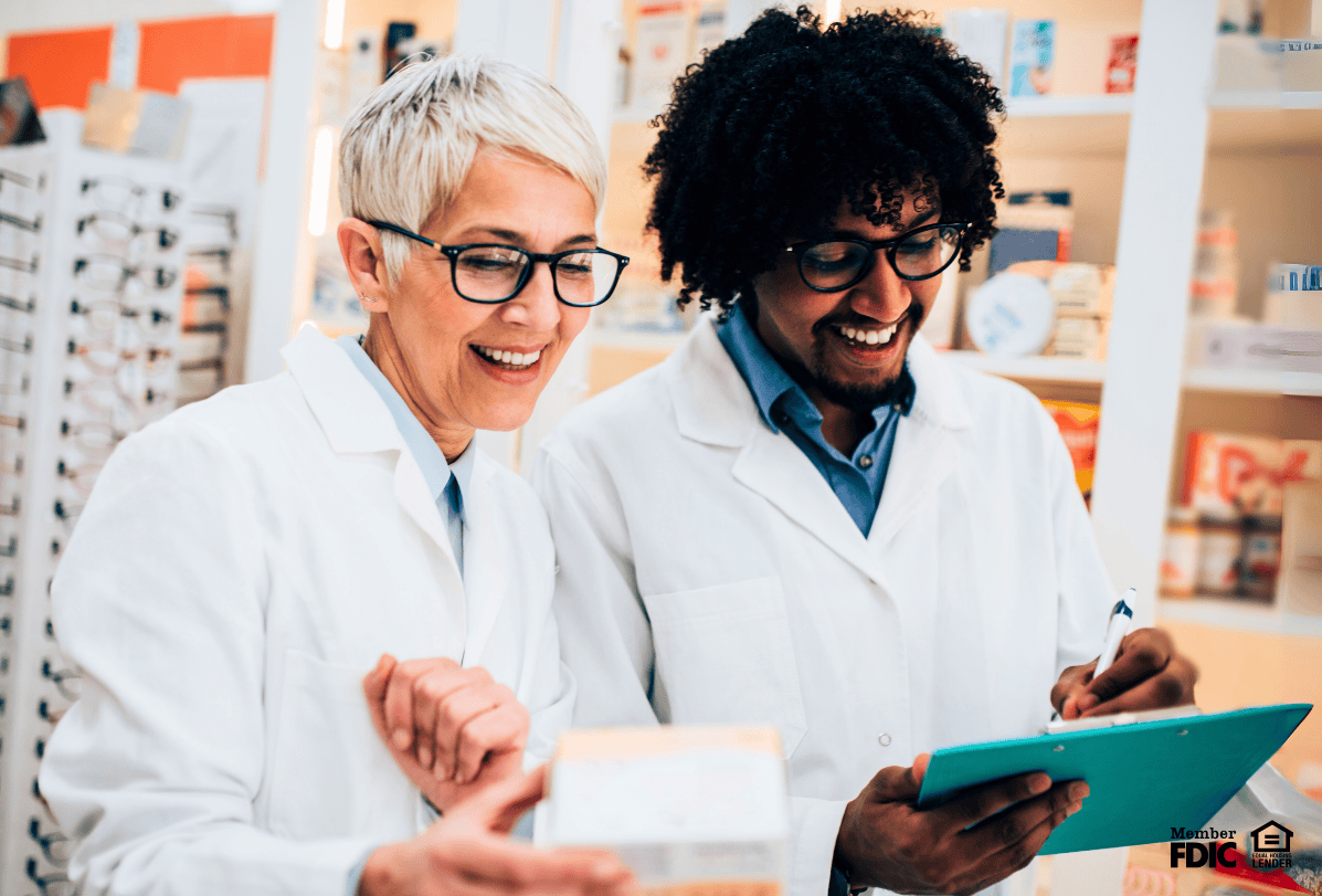 Two pharmacists working hard, feeling happy they have a special mortgage offer just for them.