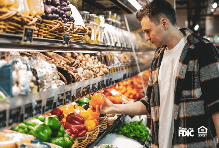 a man shops at the grocery store navigating the high prices