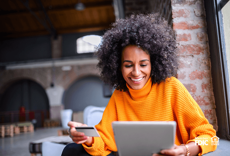 young female using her debit card to make an online purchase
