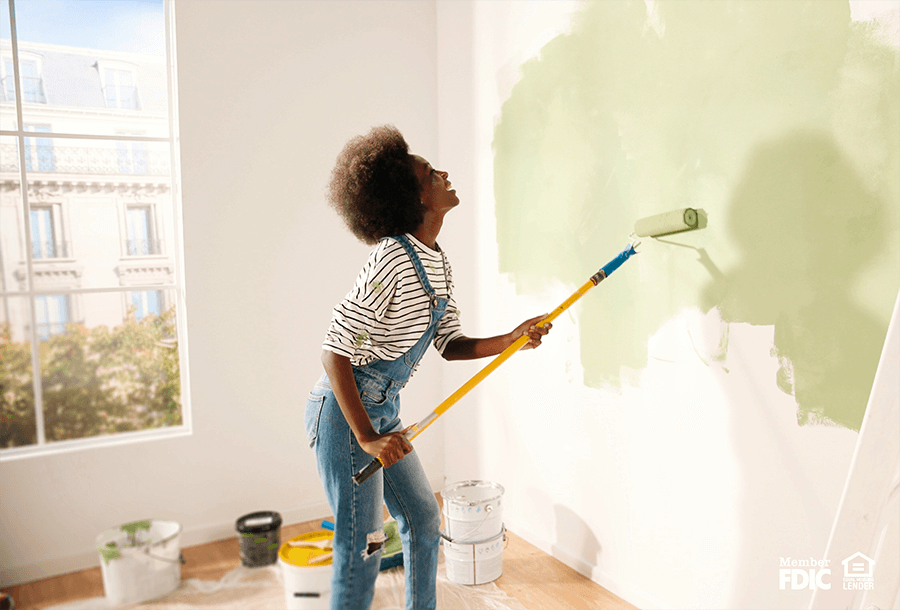 a woman repaints her walls after being approved for a home equity line of credit