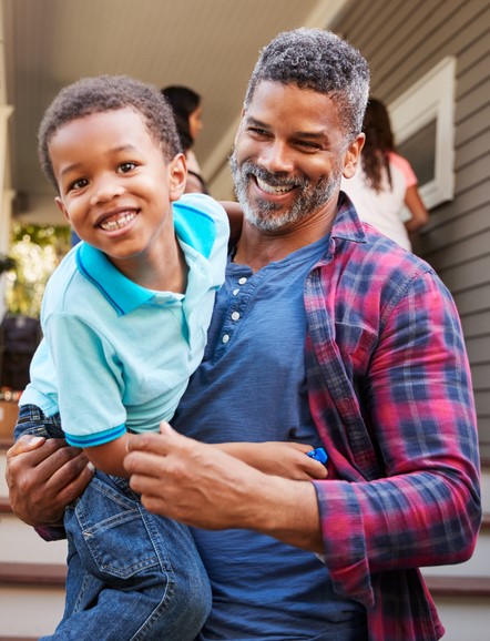 a father and son laugh together outside