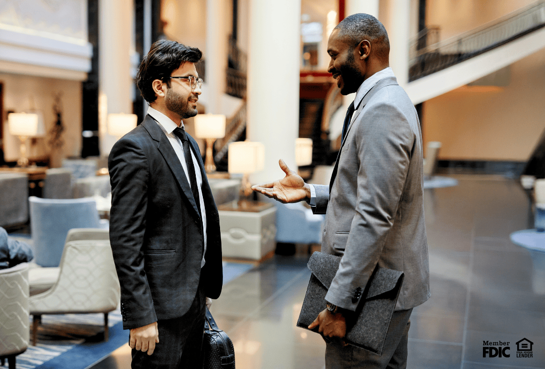 Hotel owner and commercial lender discussing commercial loan and business loan options for hotel renovation and PIPs.