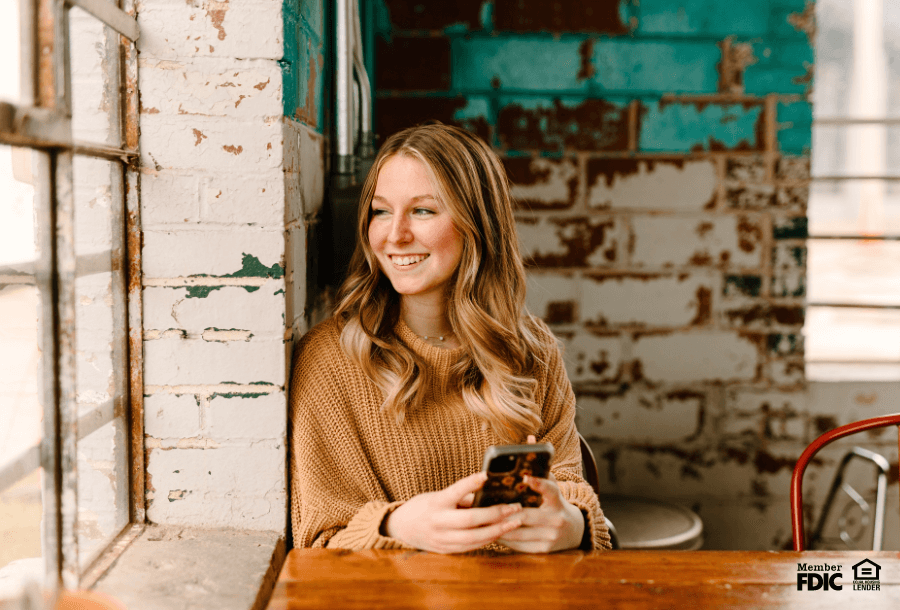 a young adult checks her credit score on her phone