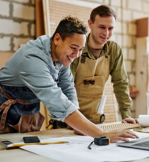 two coworkers fill out business loan applications online