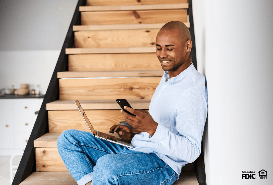 Man sitting on a staircase and calculating his debt-to-income ratio for lending.